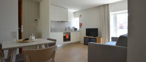 A modern living room with a sofa and a dining area with a table and chairs.