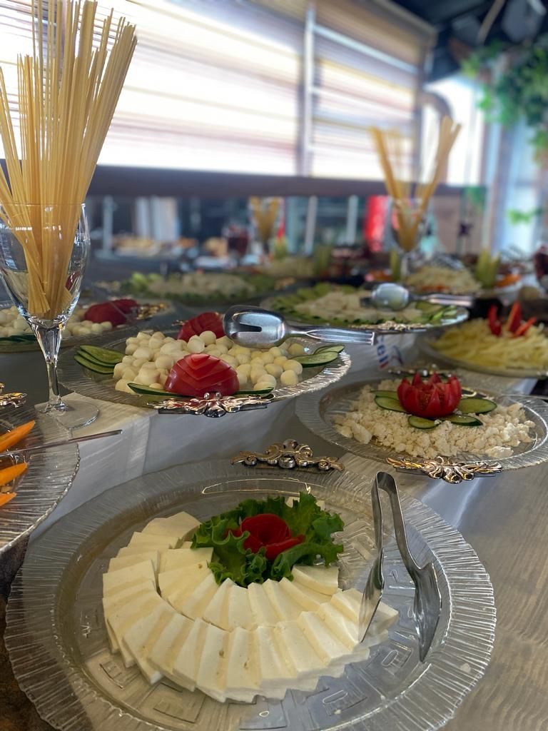 Una mesa de buffet con diversos alimentos y utensilios.