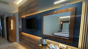 A modern kitchen with a built-in microwave, a coffee maker, and a tray of snacks. - Usak Yucel Hotel (Usak)