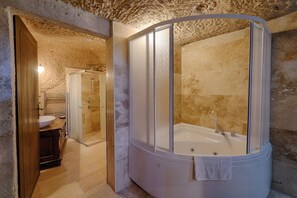 A bathroom with a bathtub, a sink, and a shower area. - Yoruk Stone House (Avanos)