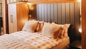 A wooden ceiling, a bed with a quilt, and a wall-mounted light fixture. - Karinna Forest Houses (Bursa)