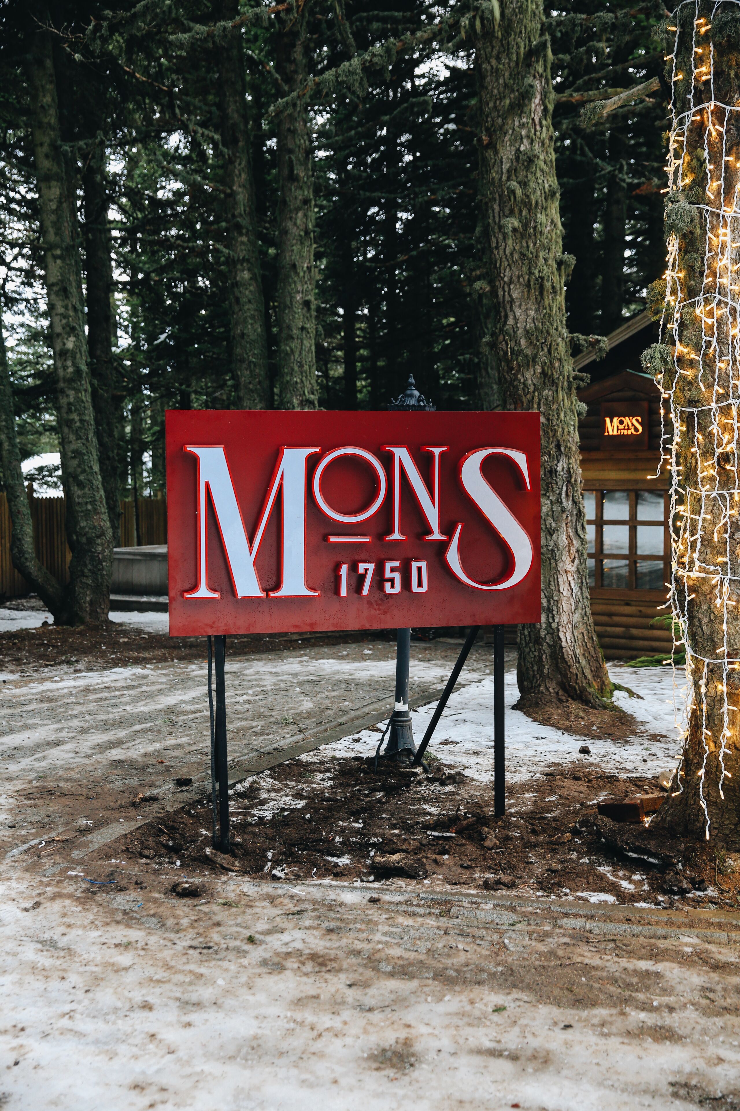 A red sign with the name "MONS 1750" in white letters, indicating the name and year of a property.