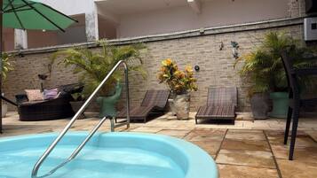 Una piscina al aire libre, tumbonas