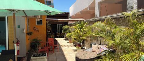 A courtyard with outdoor seating, potted plants, and a fire extinguisher.