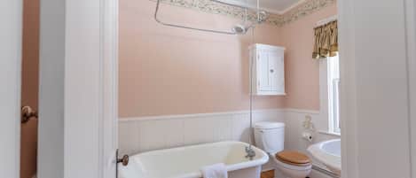 A bathroom with a freestanding bathtub, a toilet, and a sink.