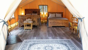 A tented accommodation with a bed, bedside tables, a window, and a rug. - Dominion Hill Country Inn (Digdeguash)