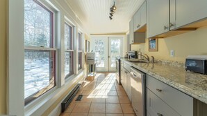 A kitchen with a large window, a sink, and a countertop. - Dominion Hill Country Inn (Digdeguash)