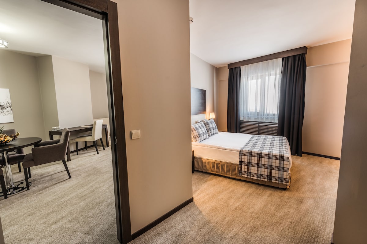 Une chambre d’hôtel avec un lit, un bureau et une chaise.