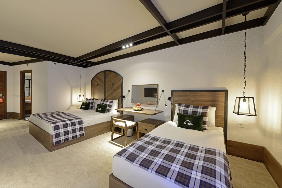Une chambre d’hôtel avec deux lits, un bureau et une chaise.