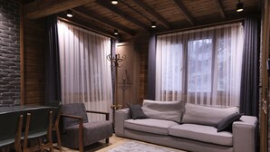 A cozy living room with a sofa, chairs, a coffee table, and a fireplace. - Uludag Orman Koskleri (Bursa)