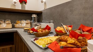 A buffet with various food items including bread, pastries, and fruits. - Trip Inn Hotel Münster City (Münster)