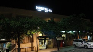 Un bâtiment sur lequel on peut lire, la nuit, une enseigne indiquant « HOSTAL ON ».