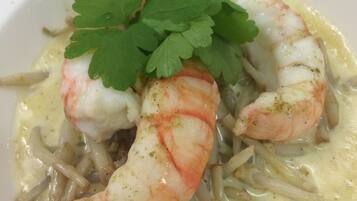 Un plato de comida con camarones y una guarnición de perejil.