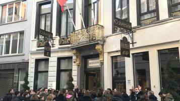 Un hôtel avec une enseigne indiquant « COLVENER RESTAURANT HÔTEL » et arborant les drapeaux de l’Union européenne et de l’Allemagne.