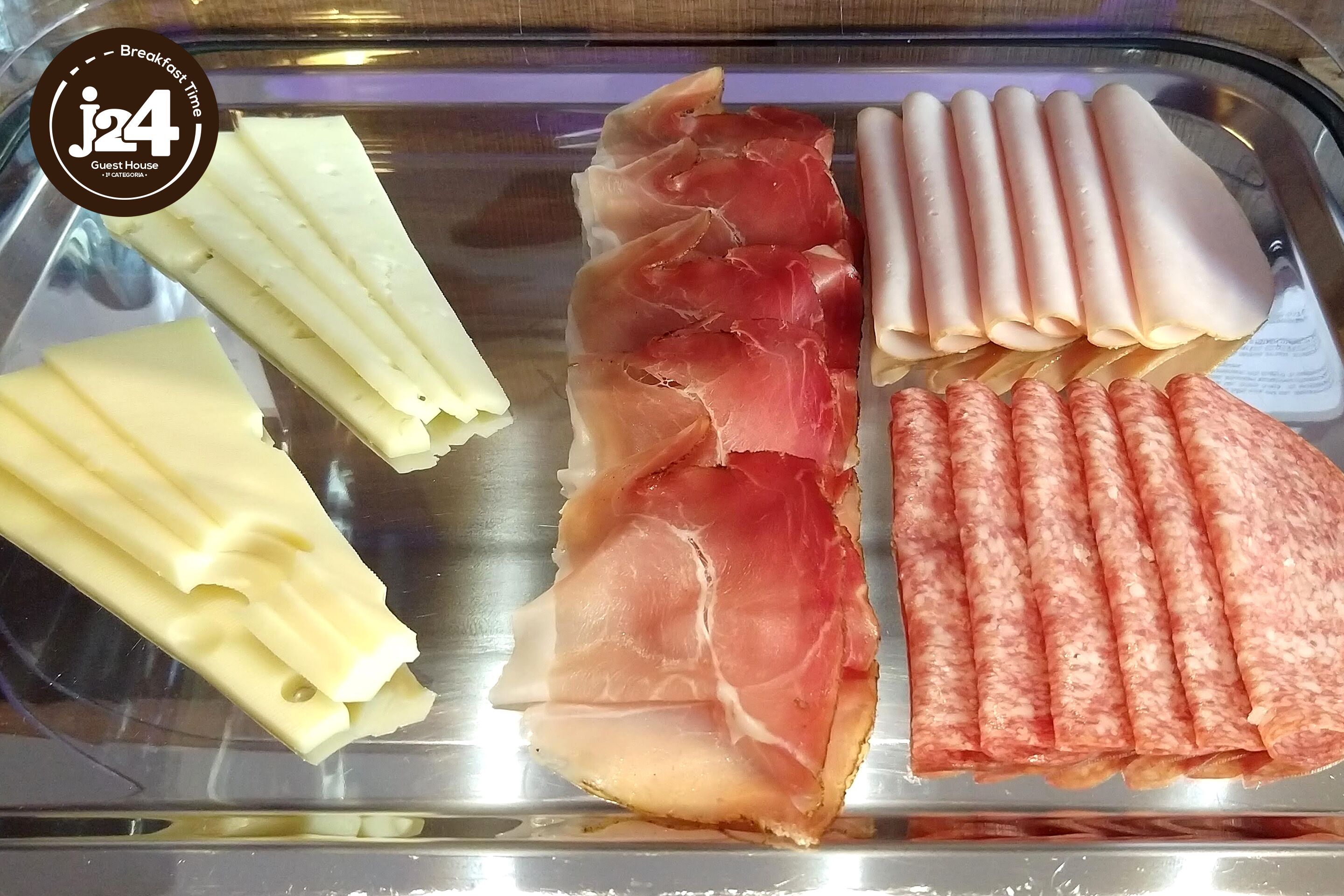 A variety of cured meats displayed on a metal tray.