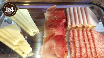 A variety of cured meats displayed on a metal tray.