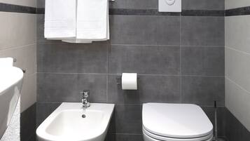 Ein modernes Badezimmer mit integriertem Bidet, Toilette und Handtuchhalter.