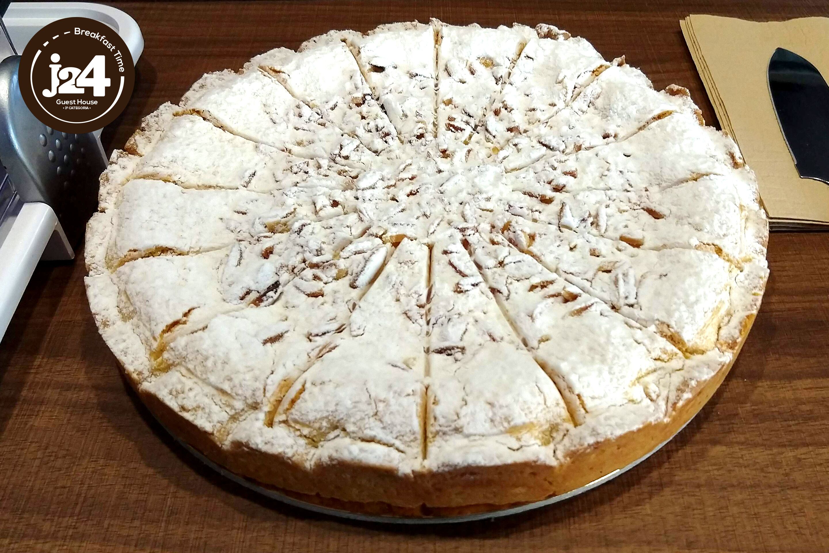 Un gâteau rond saupoudré de sucre glace, posé sur une table en bois.