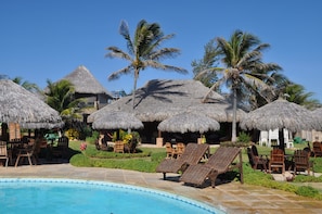 Alberca al aire libre, sombrillas en la alberca y camastros