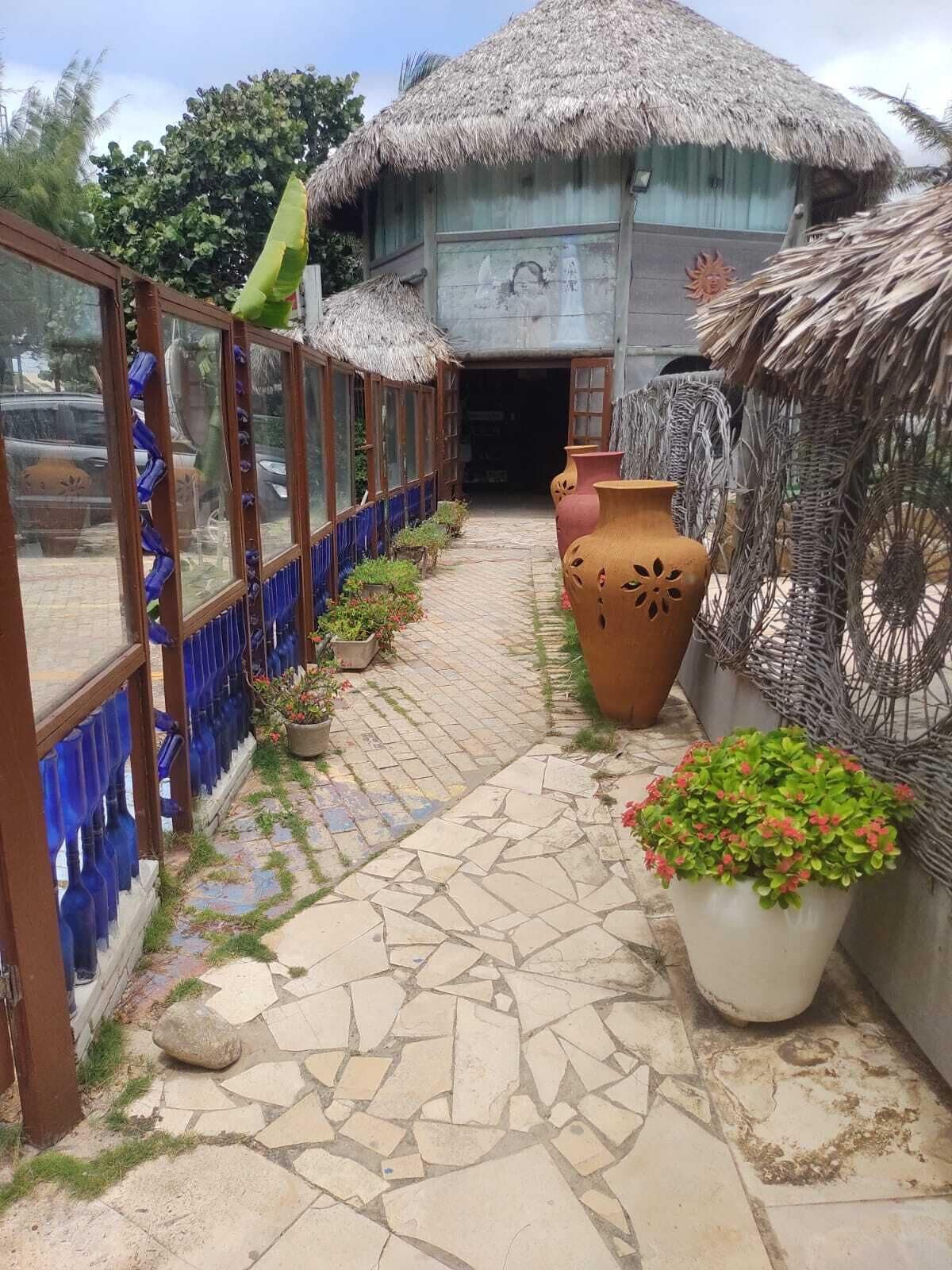 A traditional thatched-roof building with a stone pathway leading to the entrance.