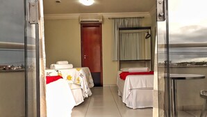 Une chambre d’hôtel avec deux lits, un balcon et une vue sur la ville.