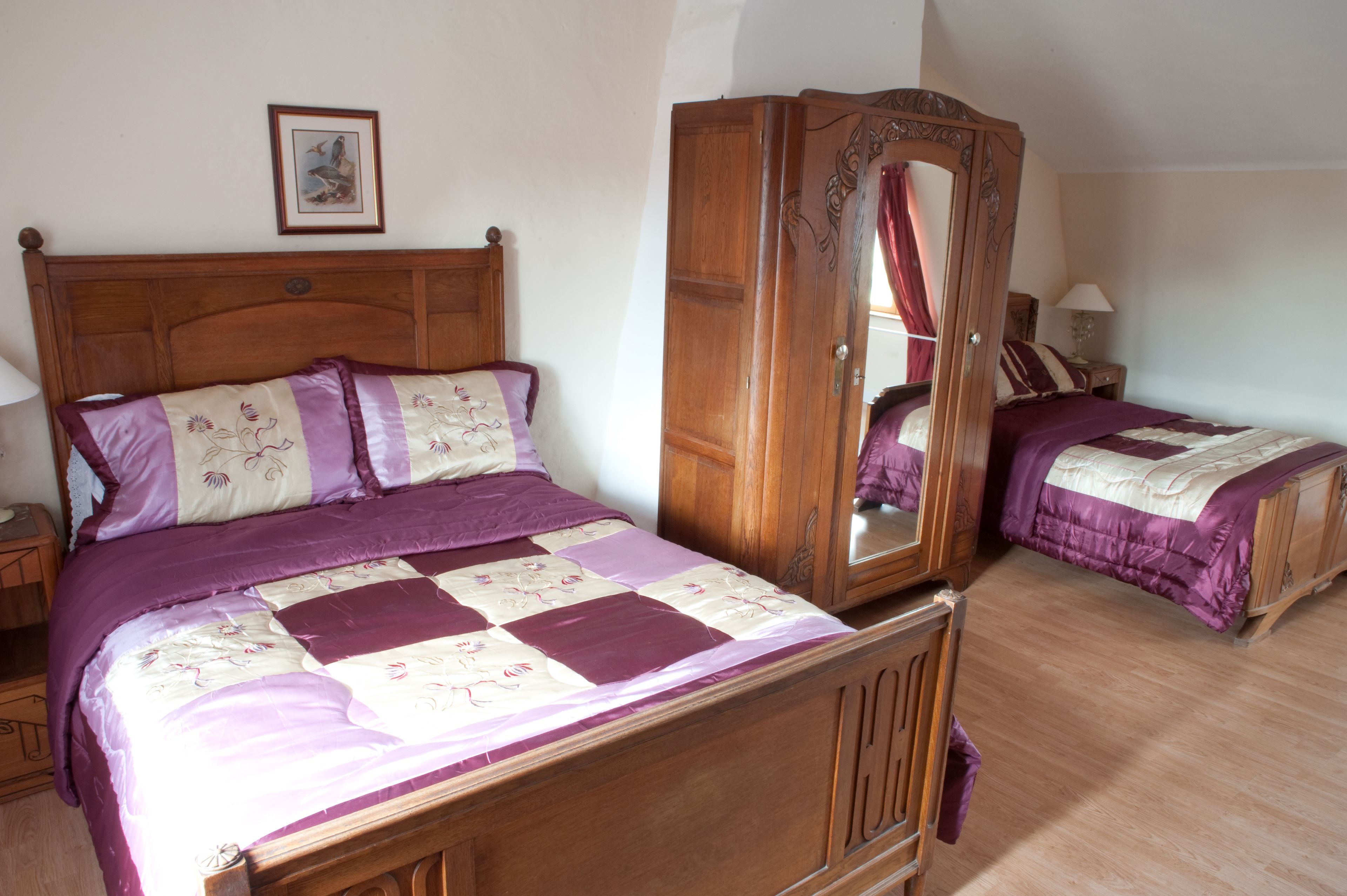 Un dormitorio con una cama de madera, un armario y una mesita de noche.