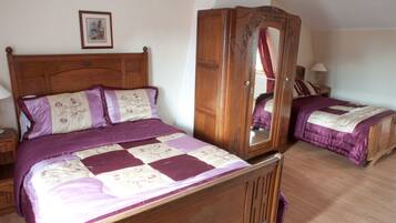 Un dormitorio con una cama de madera, un armario y una mesita de noche.