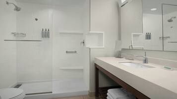 A modern bathroom with a glass-enclosed shower, a vanity with a sink, and a mirror above the vanity.
