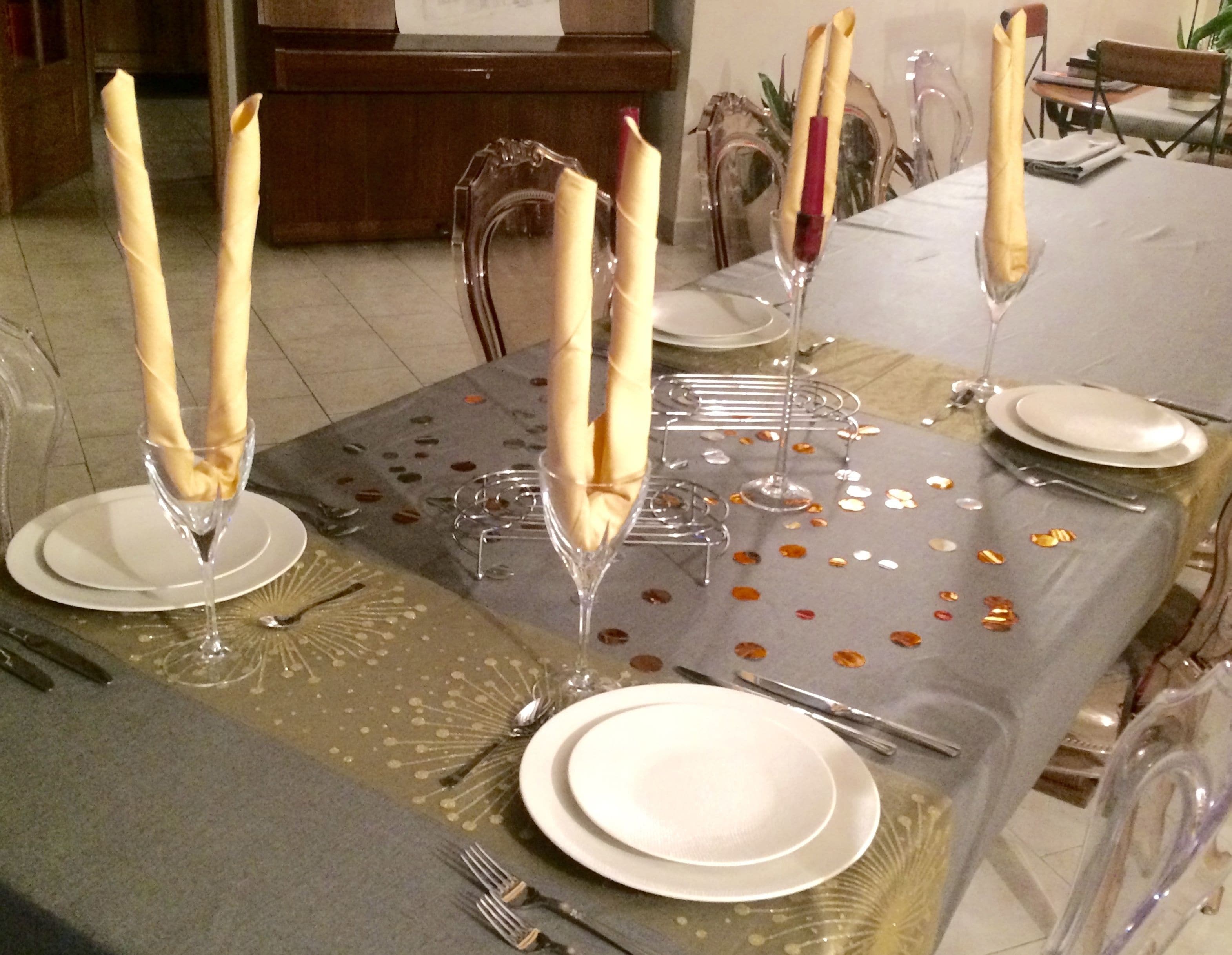 Una mesa dispuesta para una cena formal, con cristalería transparente y servilletas dobladas.