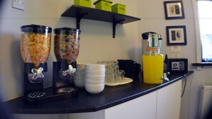 A kitchen counter with coffee makers, sugar, tea, and coffee containers. - Birchfields Guest House (Manchester)
