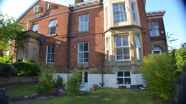 Un edificio in mattoni di due piani, con un bow window al secondo piano.