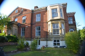 A two-story brick building with a bay window on the second floor. - Queens Guesthouse Manchester (Manchester)
