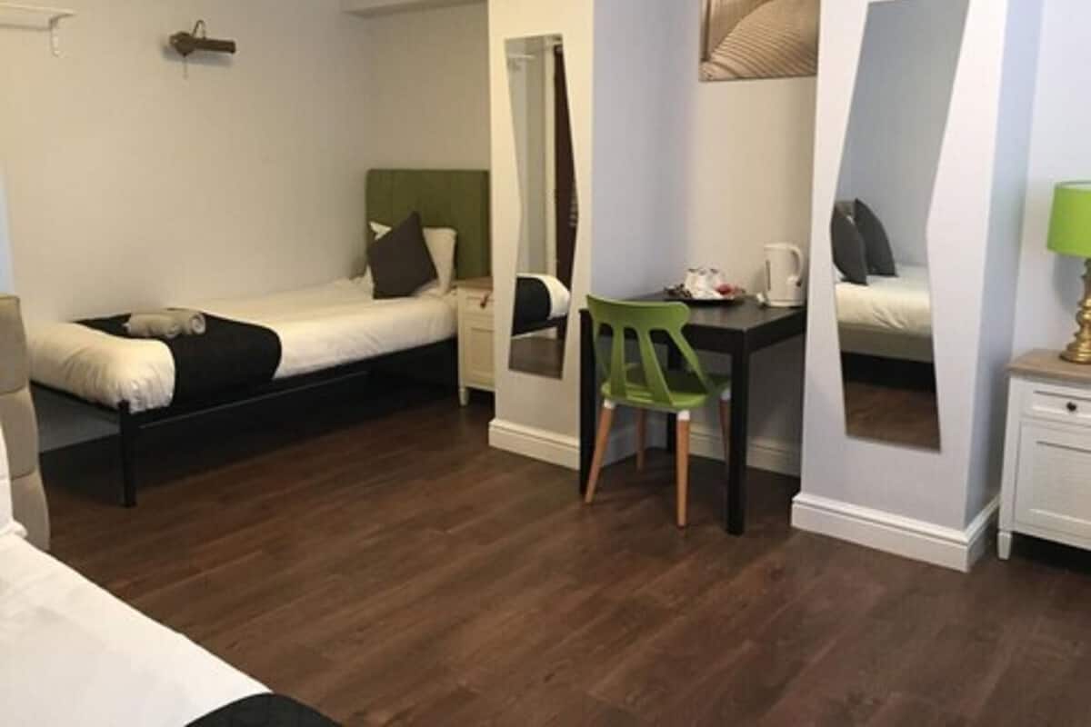 A compact bedroom with a single bed, a desk, and a chair.