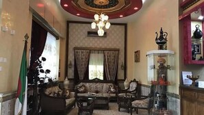 A traditional interior with a patterned carpet, a chandelier, and classic furniture. - Hôtel Adounia (Ouled Moussa)