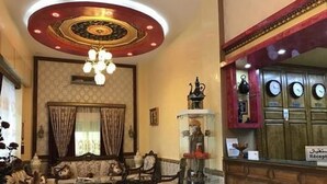 A lobby with a chandelier, a reception desk, and a seating area with a sofa and armchairs. - Hôtel Adounia (Ouled Moussa)