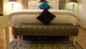 A bedroom with a bed, a bench, and two lamps.