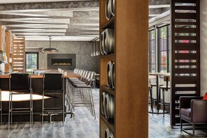 Moderni ravintola, jossa on pitkä tiski, useita tuoleja ja seinälle asennettu televisio.