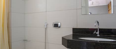 A bathroom with a toilet, a sink, and a shower.