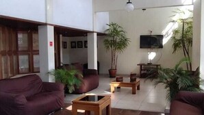 A spacious lobby with a high ceiling, large windows, and a modern design. There are several seating areas with sofas and a coffee table. - Hotel La Rocca, Goiânia  (Goiania)