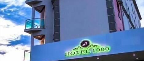A modern hotel with a prominent sign reading "HOTEL 1000".