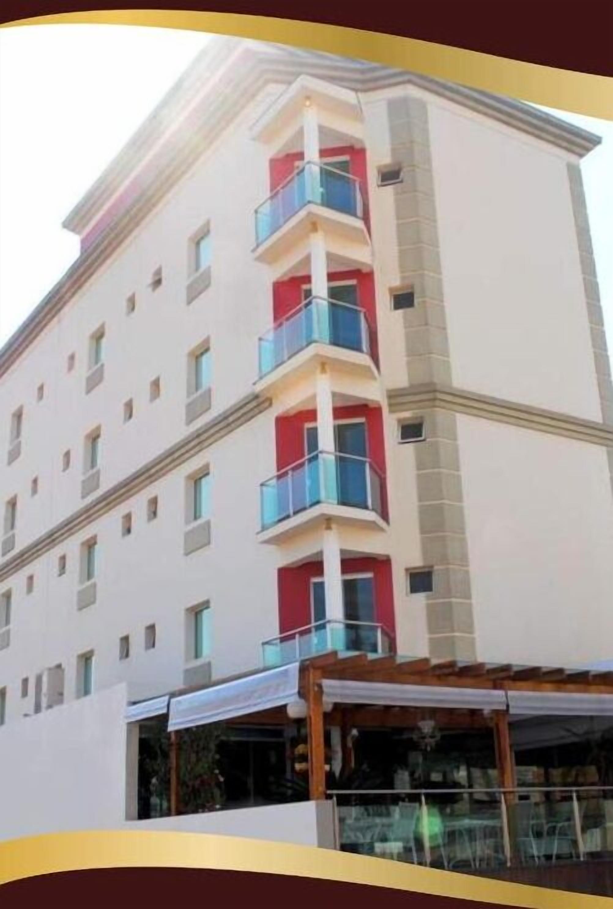 Un hotel de varios pisos con balcones, un restaurante en la planta baja y una vista despejada del cielo.