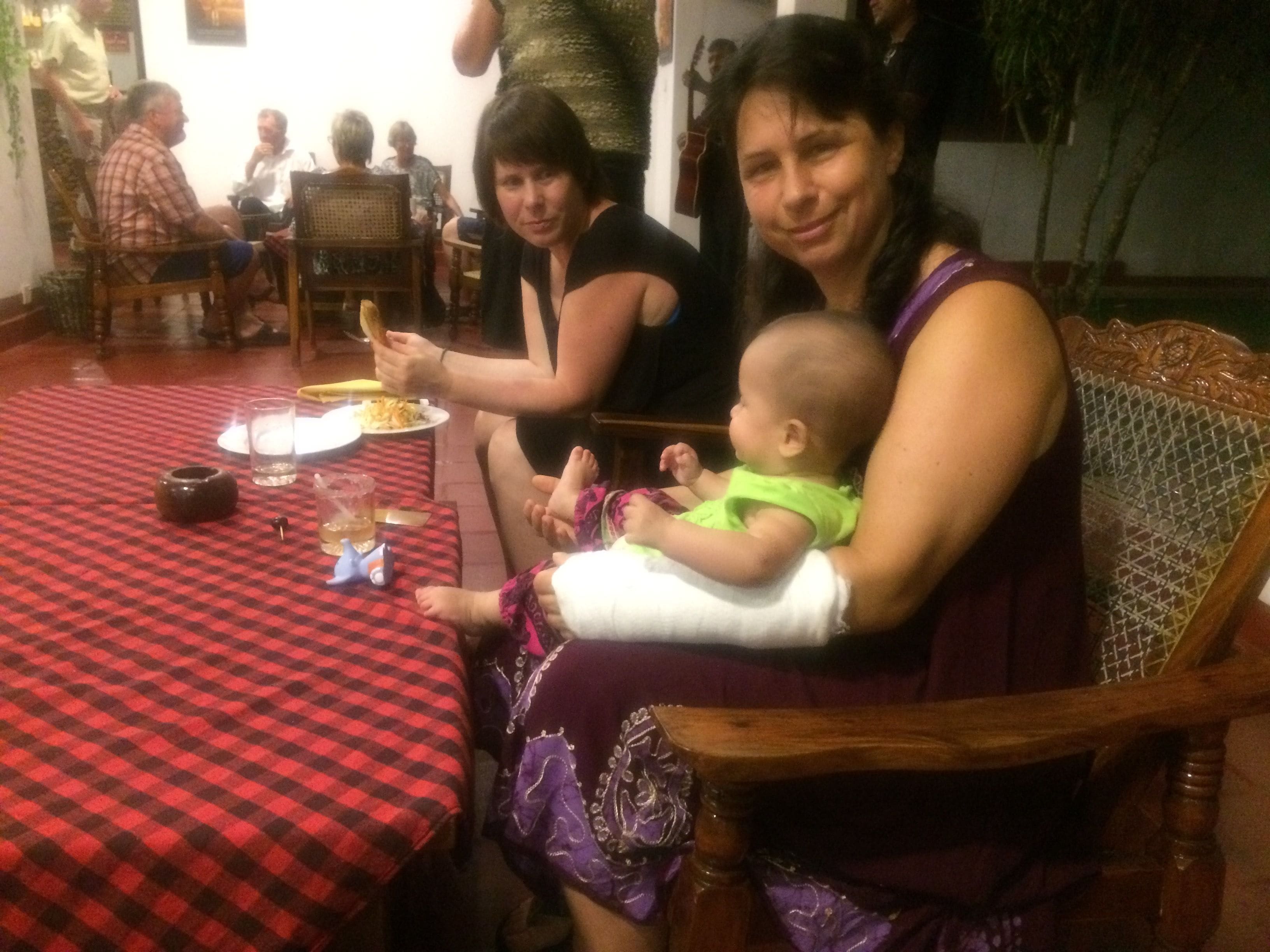 Un'area pranzo con tovaglia a scacchi, sedie di legno e seggiolino per bambini.