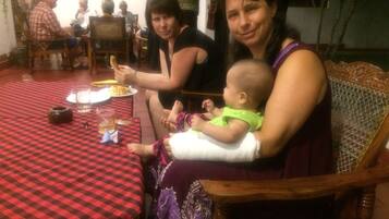 Un'area pranzo con tovaglia a scacchi, sedie di legno e seggiolino per bambini.