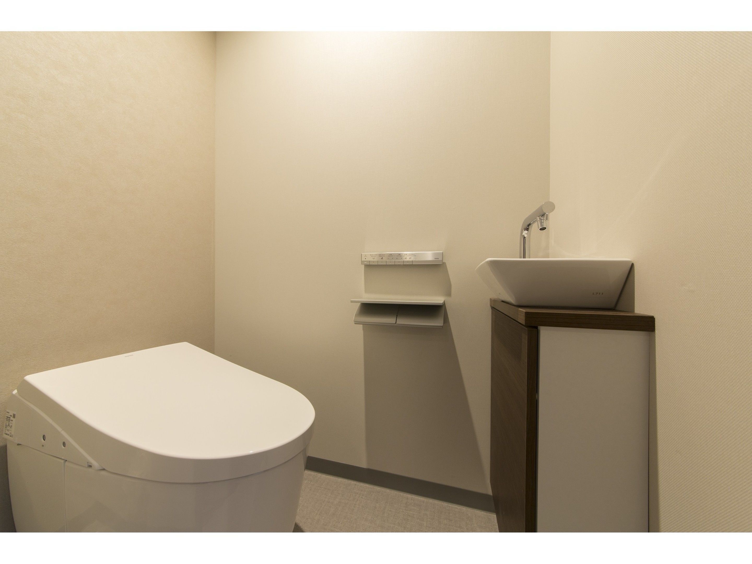 A small, clean bathroom with a toilet, a sink, and a towel rack.