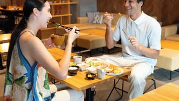 A dining area with wooden tables and chairs, a buffet with various dishes, and a modern interior design.