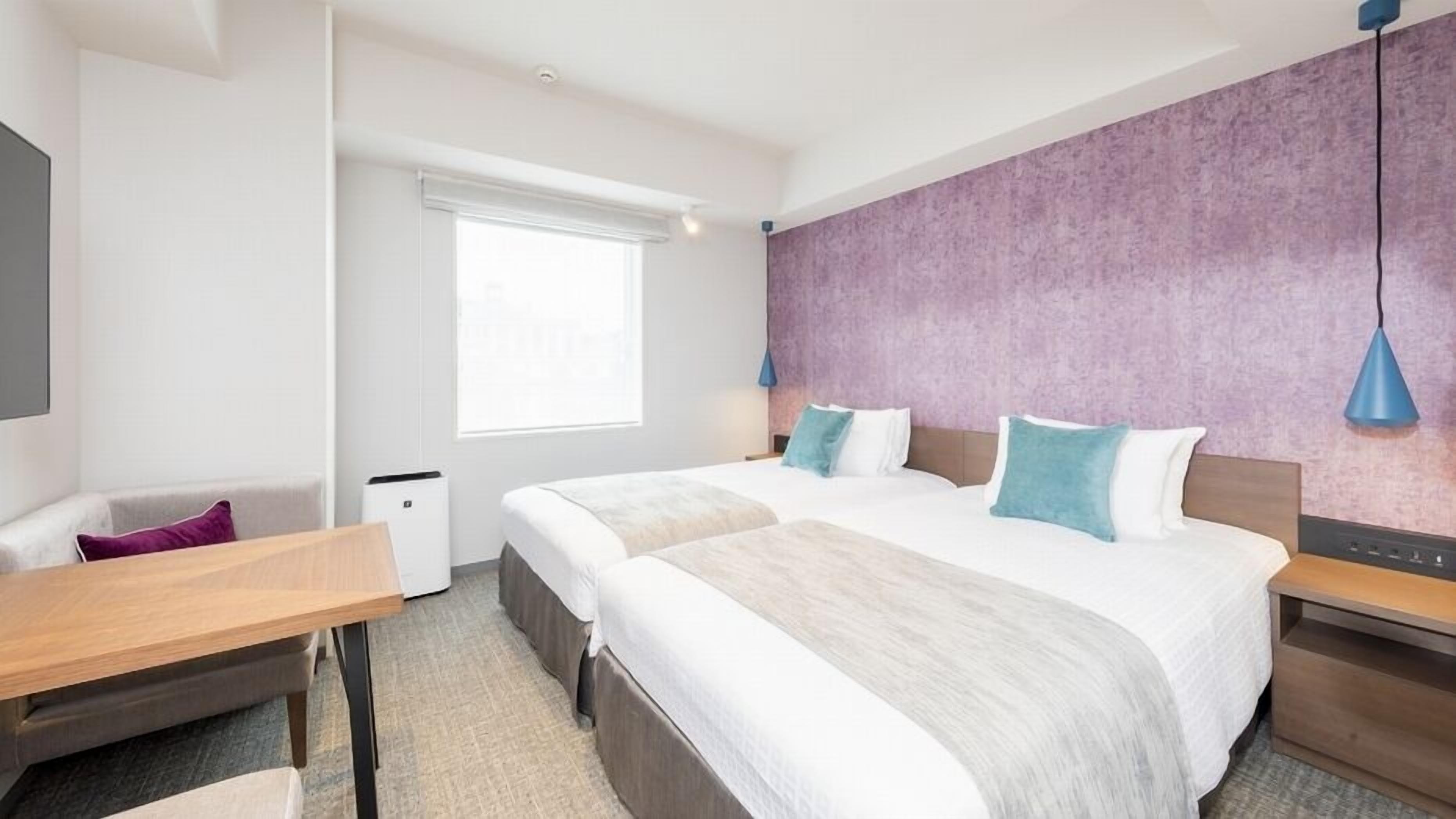 Une chambre d’hôtel avec un grand lit, un bureau, une chaise et une fenêtre.