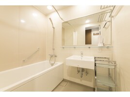 A modern bathroom with a bathtub, a sink, and a mirror.
