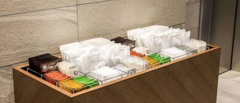 Una estación de café con varios dispensadores de bebidas y una máquina de café.