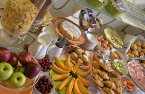 A buffet with various food items including fruits, pastries, and bread. - Villa del Sorriso (Venosa)