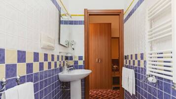 A bathroom with a white sink, a toilet, and a wooden door.